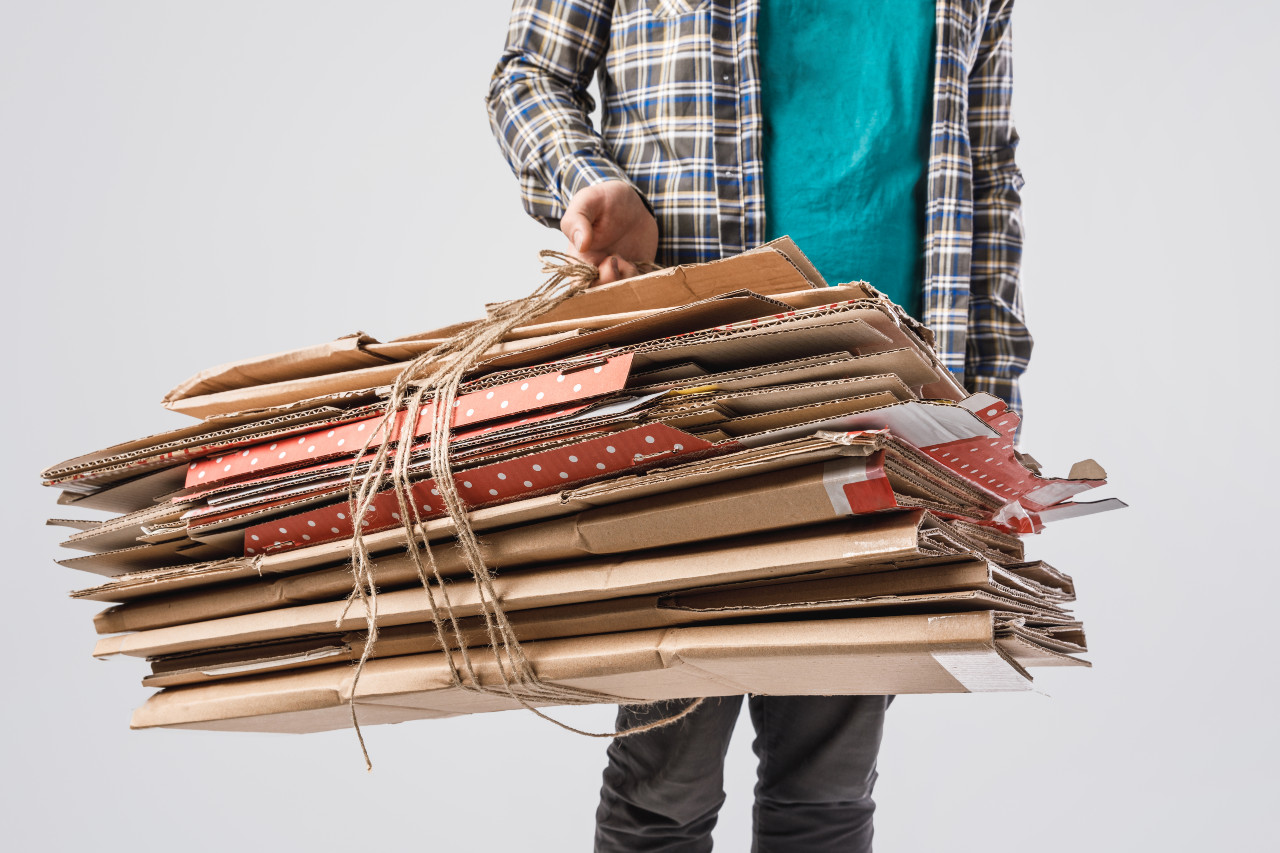 rubbish man holding flat boxes