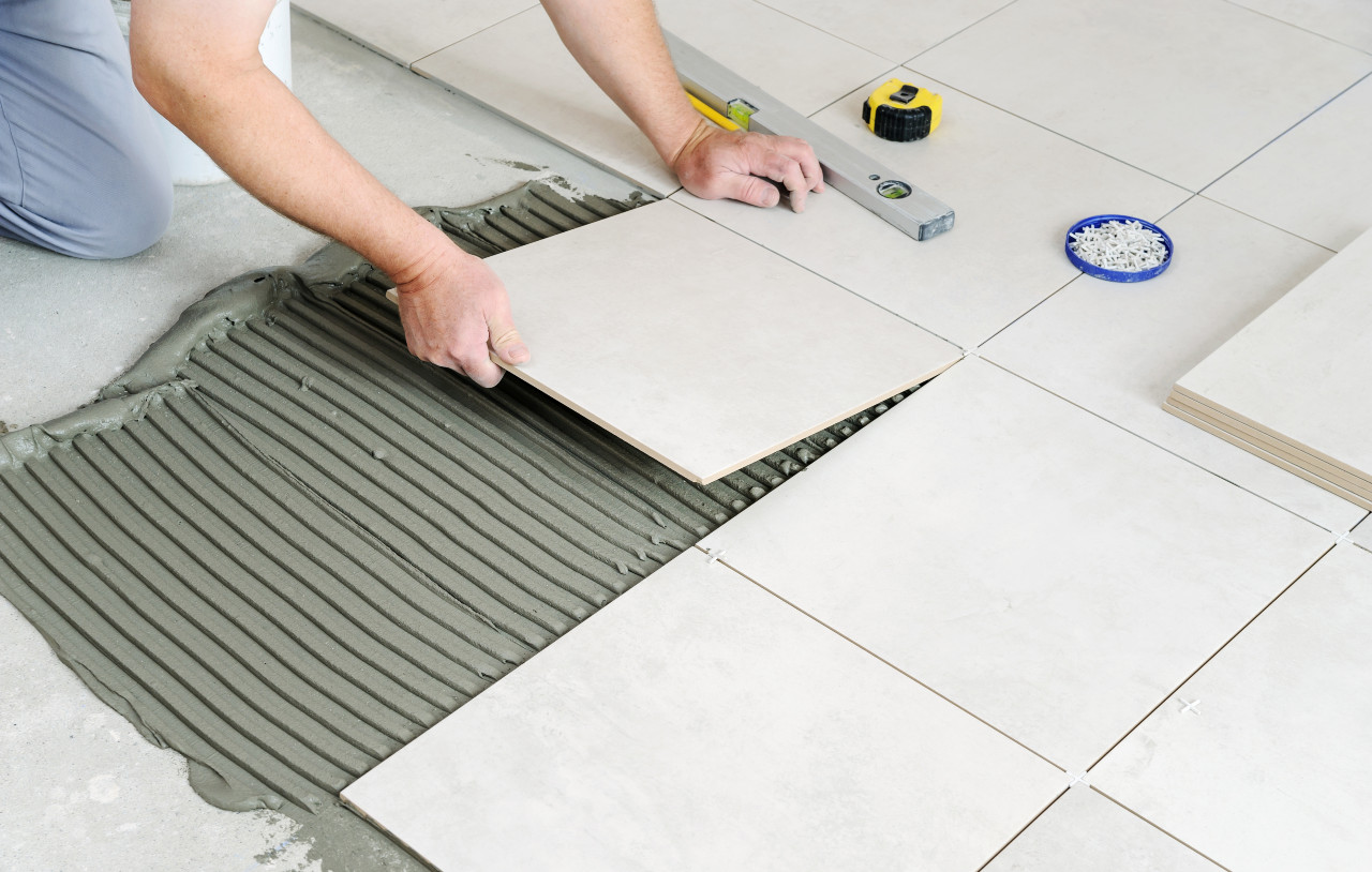 tiling image man placing floor tiles